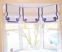 an open window with blue trim and roman shades on the windowsill, in front of a parked car