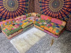 a multicolored couch sitting on top of a rug in front of a wall