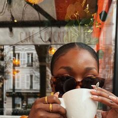 a woman holding a coffee cup in front of her face