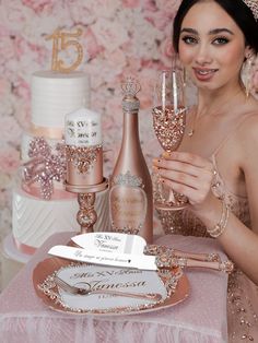 a woman in a tiara holding two wine glasses next to a cake and champagne bottle