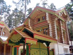 a house made out of wood and painted green, red, yellow and white colors