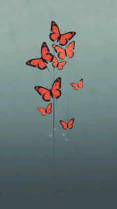 several red butterflies flying in the sky above some tall grass and flowers on a pole