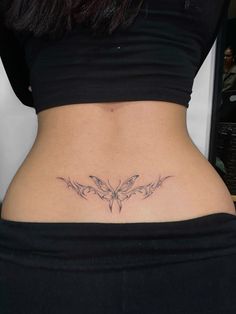 a woman's stomach with a butterfly tattoo on her lower back and the bottom part of her abdomen