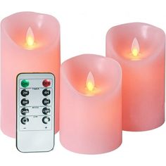 three lit candles with remote control on white background, one is pink and the other is red