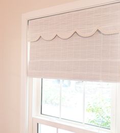 a window with a white roman blind in front of it