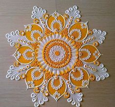 an orange and white paper doily on a wooden surface