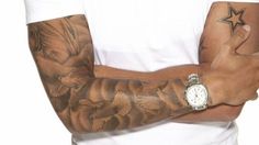 a man with tattoos on his arm and wrist