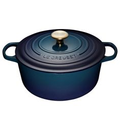 a blue casserole with a gold knob on the top is shown in front of a white background