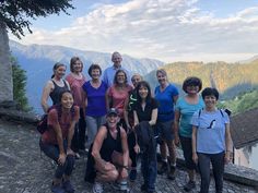 a group of people standing on top of a stone walkway next to a mountain range