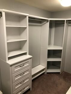 an empty walk in closet with drawers and shelves