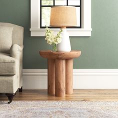 a living room scene with focus on the end table and flower arrangement in front of the window