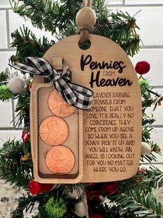 two penny christmas ornament hanging from a tree with ribbon and bow on it