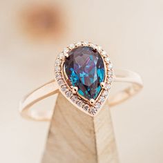 a ring with a large blue stone surrounded by small white and brown diamonds on top