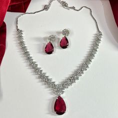 Gorgeous fine quality replica diamond and Ruby Red studded necklace with a white gold rhodium plating and matching Earrings Item contains: Necklace and earrings AAA-quality cubic zirconia was used. Highest quality and craftsmanship Necklace Fitting is adjustable Earrings Closure: Pushback Necklace Closure: chain with Hook Ruby Diamond Necklace Set, Formal Ruby Jewelry Sets With Sparkling Stones, Red Diamond Jewelry Sets Fine Jewelry, Elegant White Gold Jewelry Set With Ruby, Elegant White Gold Ruby Jewelry Sets, Elegant Ruby Jewelry Sets In White Gold, Red Cubic Zirconia Jewelry Sets For Formal Occasions, Red Diamond Fine Jewelry Sets, White Gold Ruby Jewelry For Party