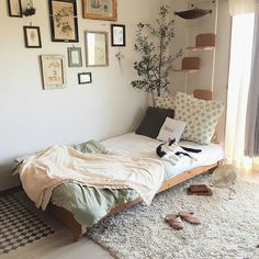 a bedroom with a bed, pillows and pictures on the wall