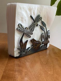 an open book with dragonflies on it sitting on a table