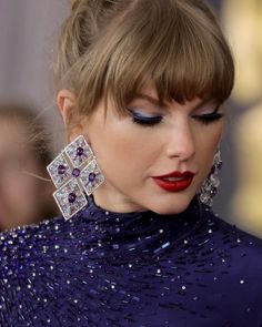 a close up of a person wearing earrings and a dress with sequins on it