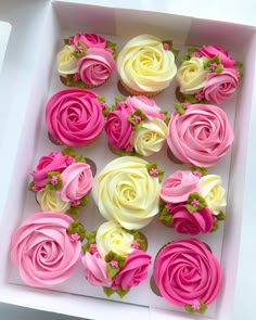 a box filled with cupcakes covered in pink and white frosting roses on top of each other