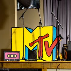 a table topped with musical equipment next to a painting on the side of a wall