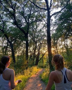 two women walking down a trail in the woods