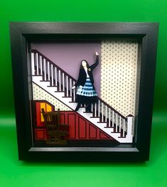 Beetlejuice inspired 3D box frame of the iconic floating dance scene. This frame has been meticulously designed with a high level of detail, right down to the wallpaper design and a stained wooden rocking chair! A truly unique item, which is perfect for any fan. Box Material - Wood Aperture size: 15 x 15cm  Internal depth: 2cm External frame: 19 x 19cm External depth: 3.5cm  Includes wall hanging clip for mounting. 3d Picture Frame, 3d Box Frames, Wooden Rocking Chair, Wooden Rocking Chairs, 3d Pictures, Wallpaper Design, Beetlejuice, Box Frames, Rocking Chair