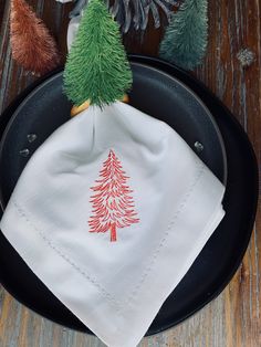 a small christmas tree on a white napkin in a frying pan with pine cones