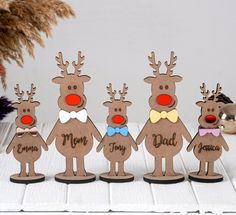 a group of wooden reindeer standing next to each other on top of a white table