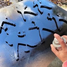 someone is spray painting the side of a car tire with black paint and some other things on it