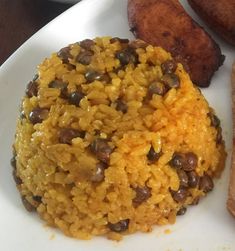 a white plate topped with rice and beans next to two pieces of toasted bread