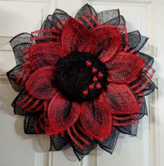 a red and black mesh flower on a door