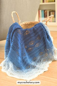 a blue crocheted bag sitting on top of a wooden floor next to a book shelf