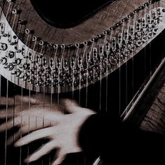 a close up of a person's hand playing a musical instrument with strings attached to it