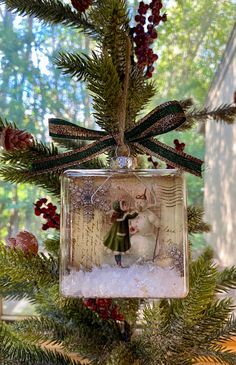 a glass ornament hanging from a christmas tree