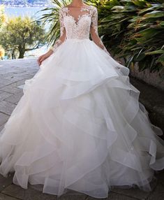 a woman in a wedding dress is standing outside