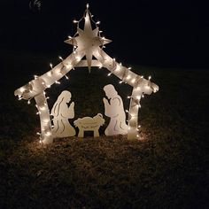 a lighted nativity scene in the grass