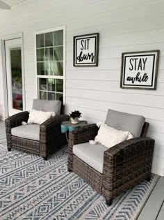 two wicker chairs sitting on top of a blue rug next to a white house