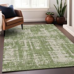 a living room area with a chair and rug in front of a window, potted plant on the floor