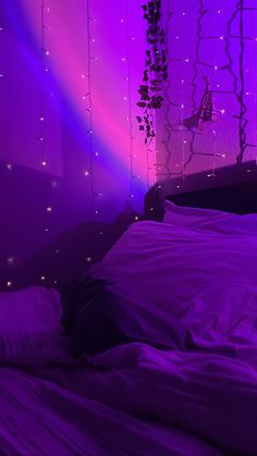 a bed with white sheets and purple lights