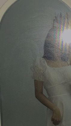 a woman is standing in front of a mirror wearing a white dress and holding a cell phone