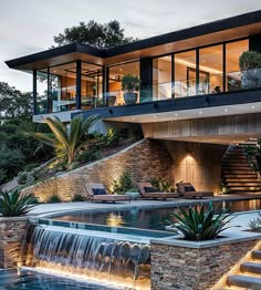 a house with a pool and waterfall next to it