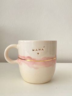 a coffee cup with the word mama written in gold on it's bottom and inside