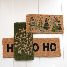 three doormats with christmas trees on them and the word ho hoo written in black