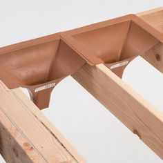 two brown planters sitting on top of wooden posts in front of a white wall