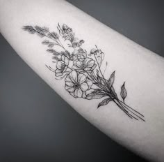 a black and white photo of flowers on the arm