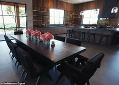 a large dining room table with chairs and vases on the table in front of it