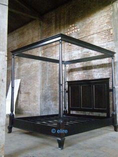 a metal bed frame in the middle of a room with brick walls and flooring