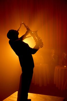 a man is playing the saxophone on stage