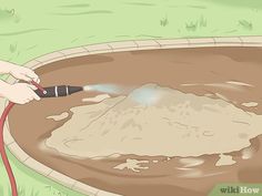 a person is spraying water into a bowl with a garden hose in the middle of it