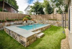 a backyard with a swimming pool and landscaping