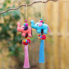 three colorful poodles hanging from a tree branch in the yard, one has a pink poodle on it's head and another has a blue poodle on its neck